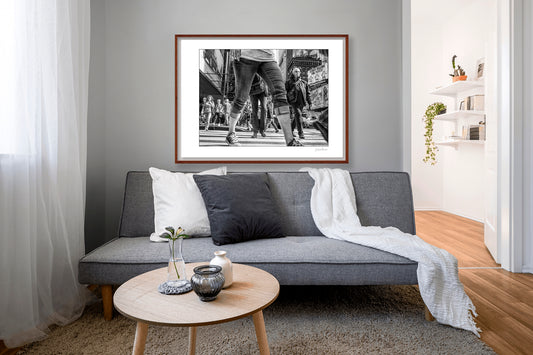 Black & White photograph of people walking in Times Square with low perspective