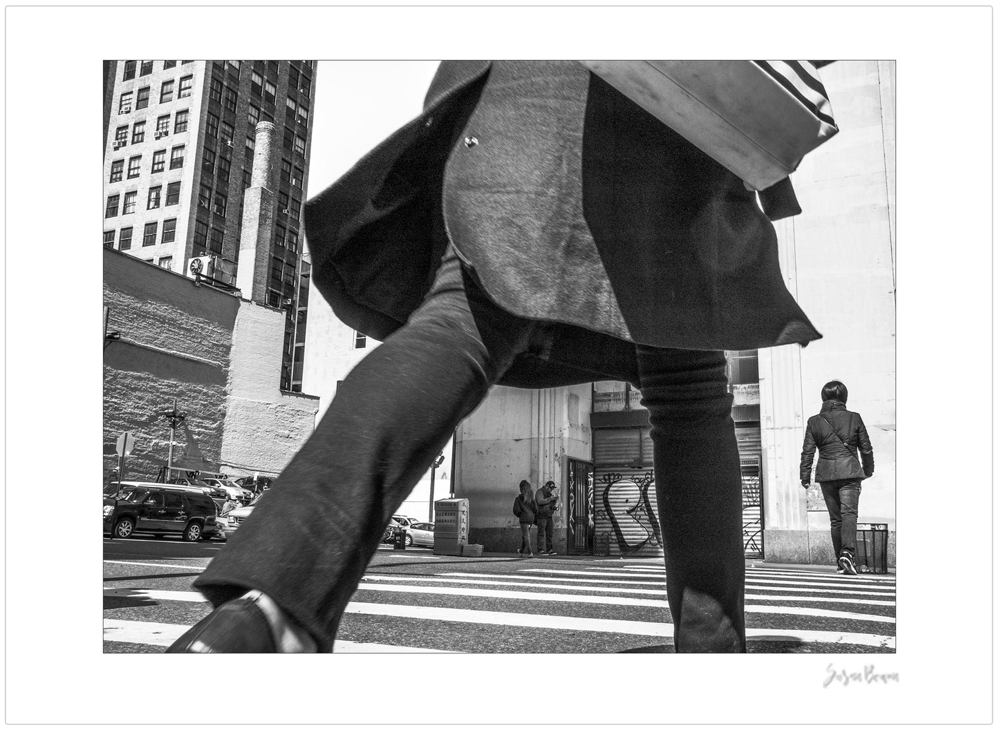 Black & White photograph of people walking in New York City with low perspective