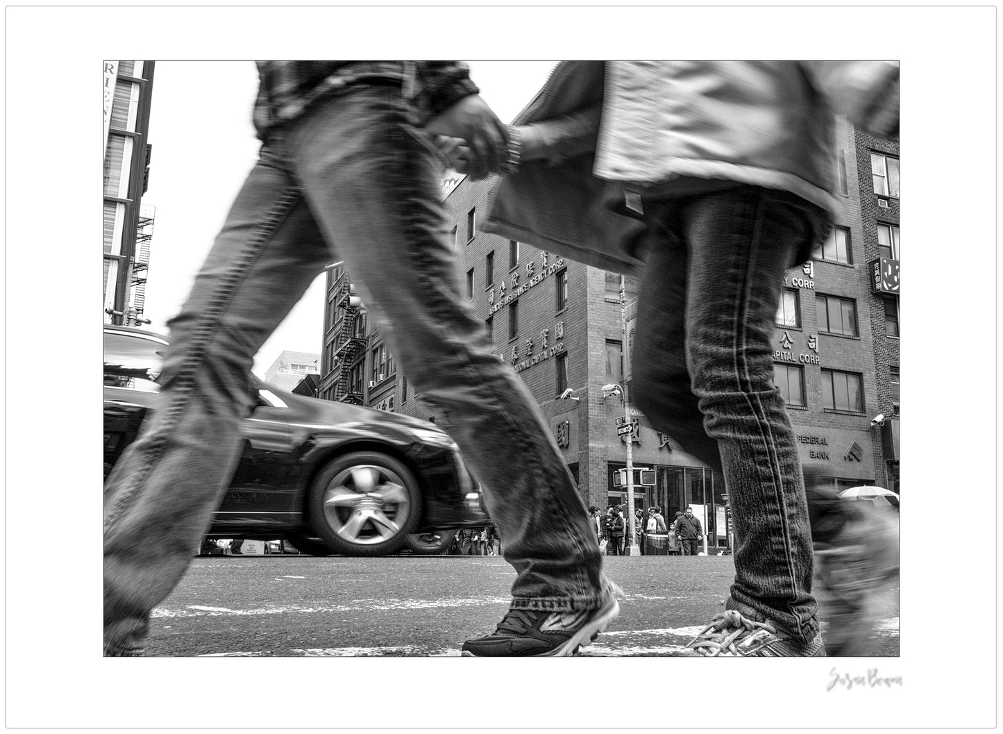Black & White photograph of people walking in New York City with low perspective