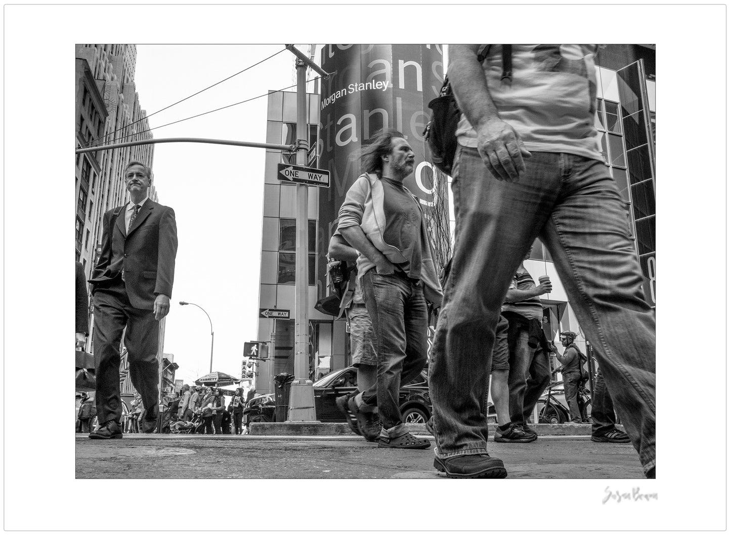 Black & White photograph of people walking in Times Square with low perspective