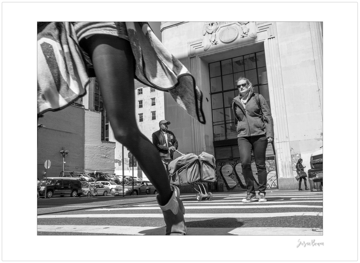 Black & White photograph of people walking in New York City with low perspective