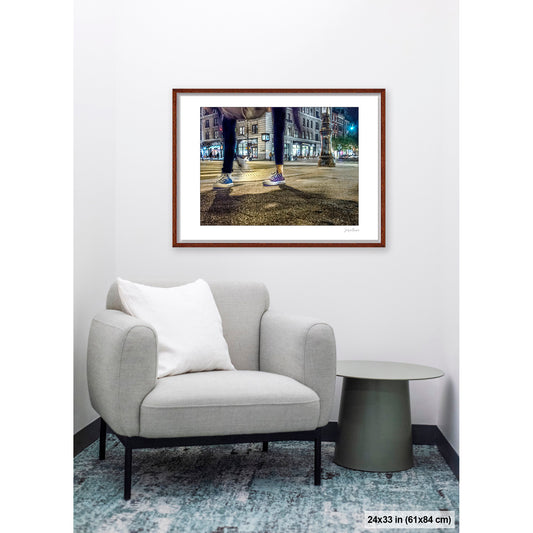 Mis-Matched Legs artwork by Susan Bowen, shown as 24x33 framed print. Features night photograph of two mismatched pairs of Converse sneakers at a lit NYC intersection, one still, one in motion.