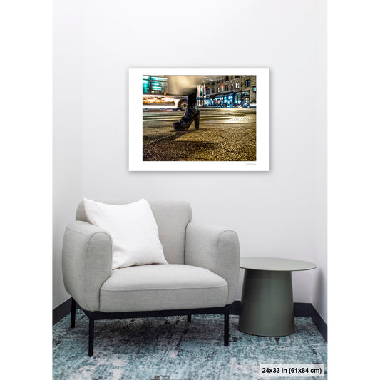 High-Heeled Shoe and Bus artwork by Susan Bowen, shown as 24x33 print. Features long-exposure night photograph of a single high-heeled shoe on a NYC crosswalk as a city bus streaks past behind it.