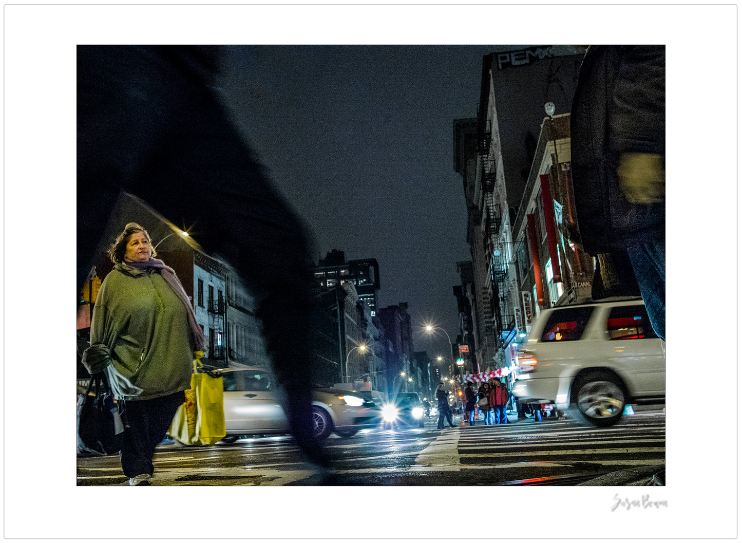 Photograph of blurry leg and person crossing intersection in Chinatown in New York City with low perspective