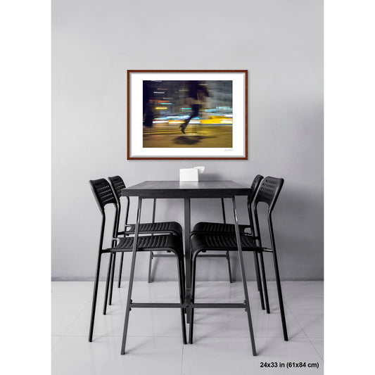 Rushing Figure and Lights artwork by Susan Bowen, shown as 24x33 framed print. Features long-exposure night photograph of a figure mid-stride against streaking neon and taxi lights on a Midtown crosswalk.
