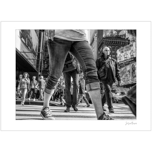 Black & White photograph of people walking in Times Square with low perspective
