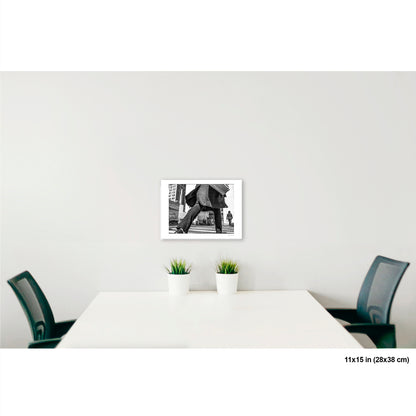 Canal Street Looming Figure artwork by Susan Bowen, shown as 11x15 print. Features low-angle B&W photograph of a figure mid-stride at Canal Street, coat billowing, dwarfing the city behind them.