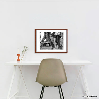 Couple in Chinatown artwork by Susan Bowen, shown as 16x22 framed print. Features low-angle B&W photograph of a couple crossing hand-in-hand through a Chinatown intersection, motion-blurred mid-stride.