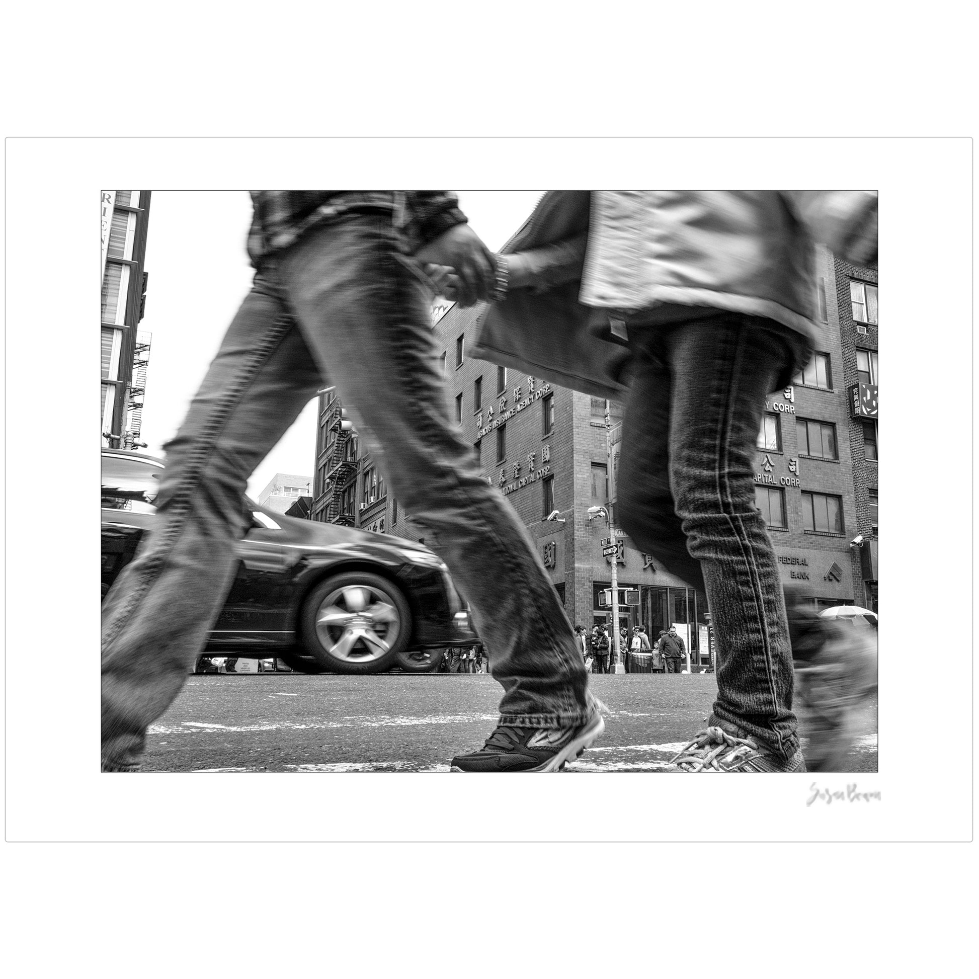 Black & White photograph of people walking in New York City with low perspective