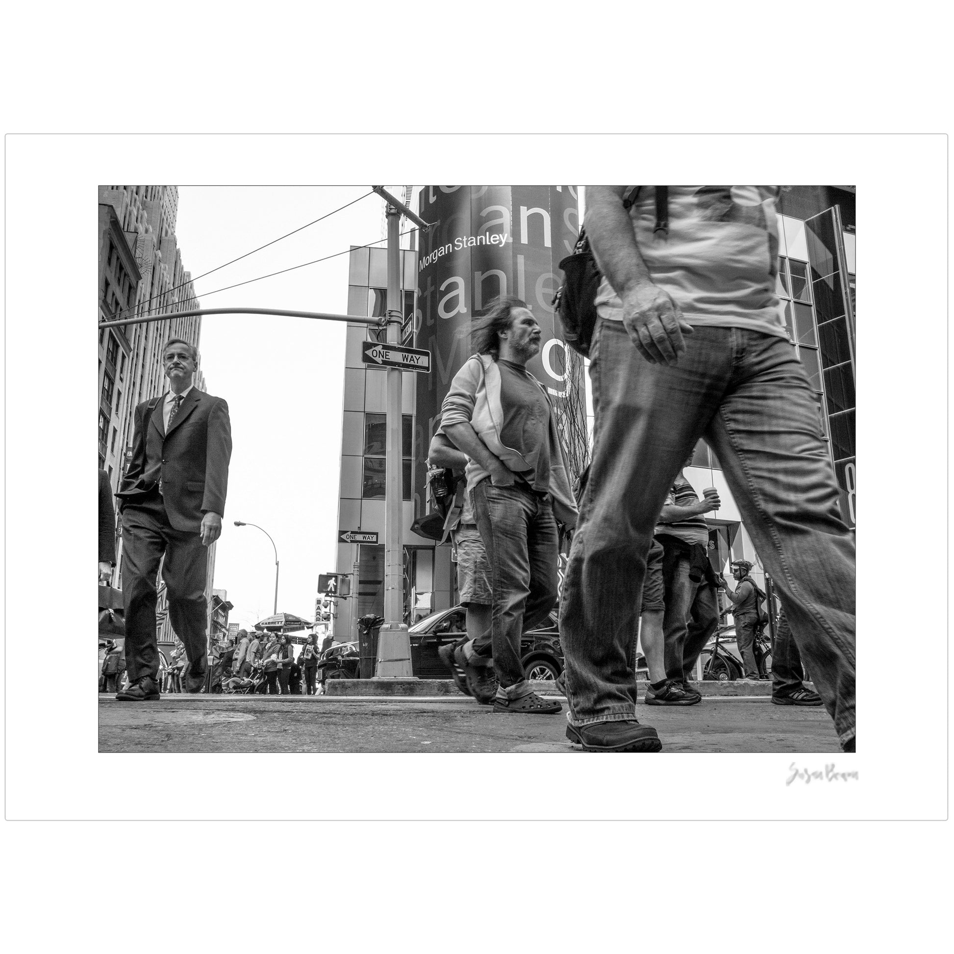 Black & White photograph of people walking in Times Square with low perspective