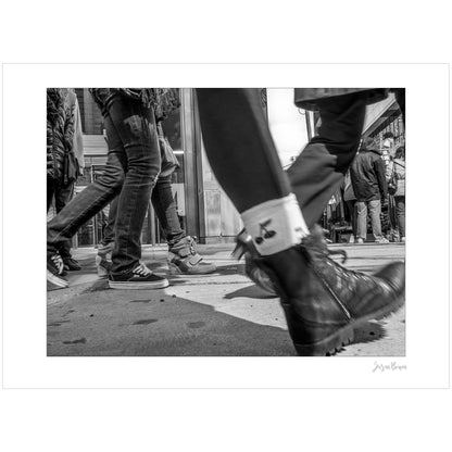 Black & White photograph of people walking in Times Square with low perspective