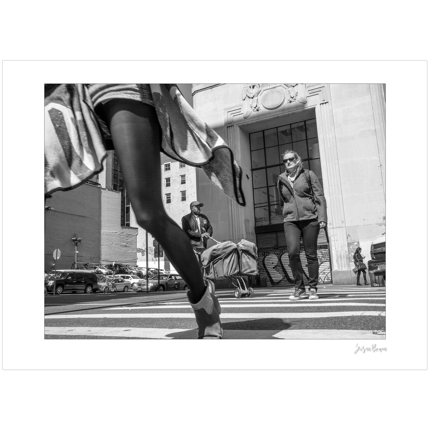 Black & White photograph of people walking in New York City with low perspective