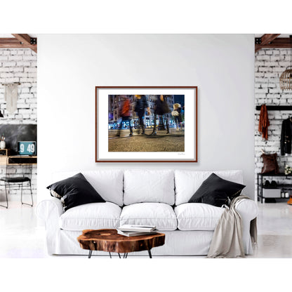 Photograph of 4 blurry people walking at night in New York City with low perspective