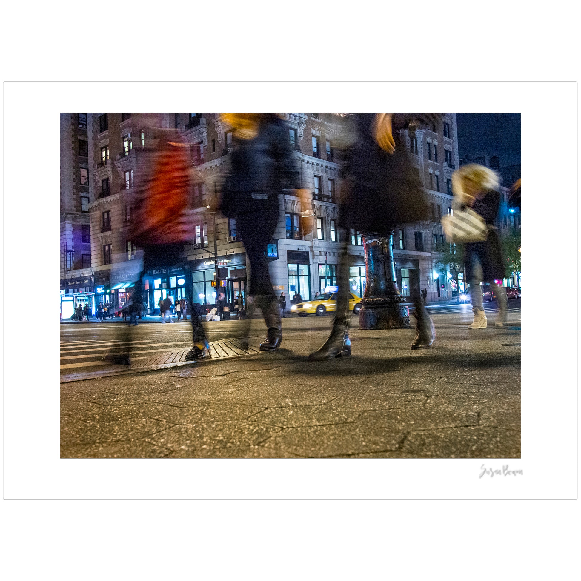 Photograph of 4 blurry people walking at night in New York City with low perspective