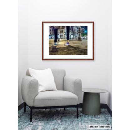Mis-Matched Legs artwork by Susan Bowen, shown as 24x33 framed print. Features night photograph of two mismatched pairs of Converse sneakers at a lit NYC intersection, one still, one in motion.