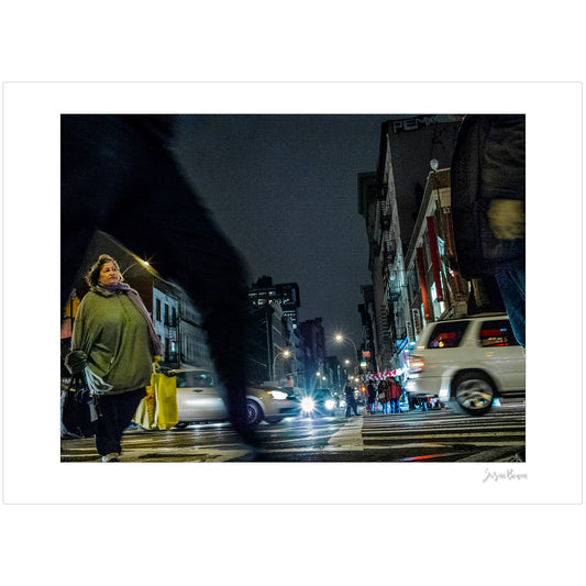 Photograph of blurry leg and person crossing intersection in Chinatown in New York City with low perspective